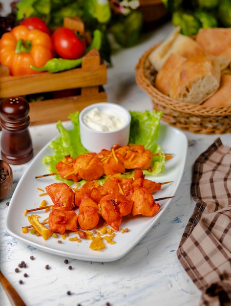 Chicken breast pieces sish kebab, grilled and served with cream sauce, sumakh and lettuce