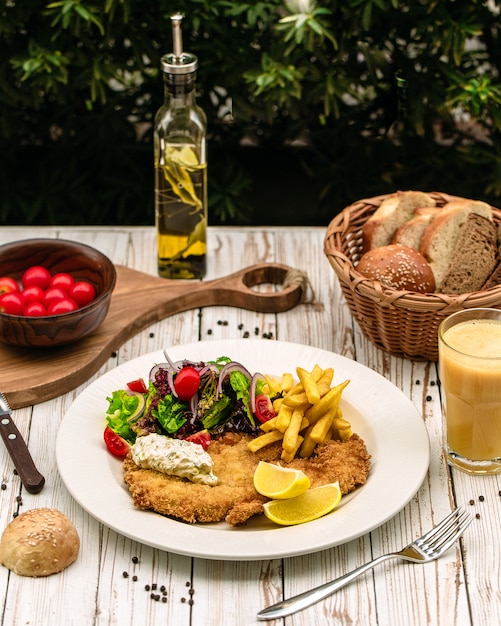 Chicken breast served with fries and vegetables