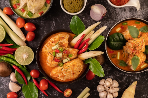 Free Photo chicken curry in a bowl with lemongrass, kaffir lime leaves, tomatoes, lemon, and garlic