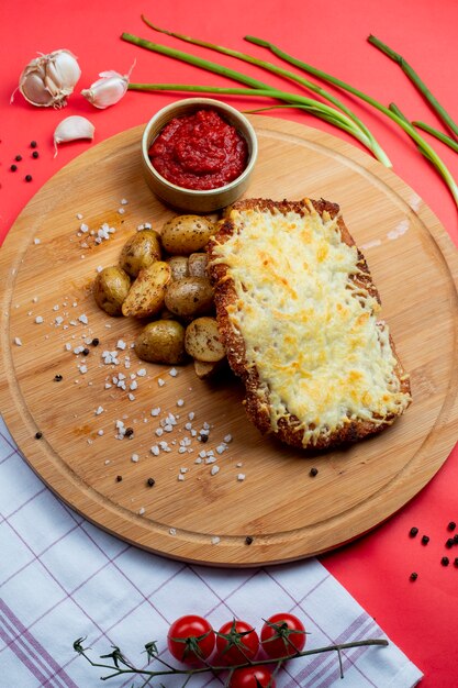 Chicken cutlet topped with melted cheese and side potatoes