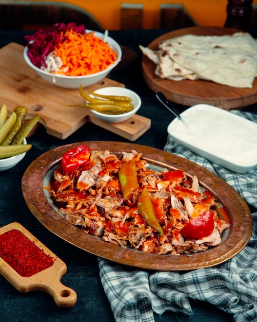 Free photo chicken doner slices garnished with tomato sauce, pepper and fresh tomato