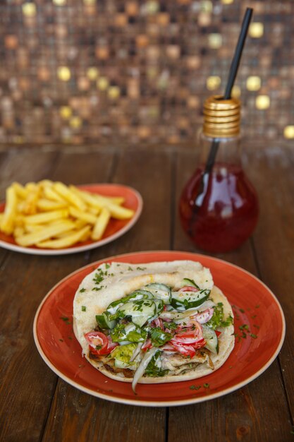 Chicken doner with lettuce, cucumber, tomato and herbs in pita bread