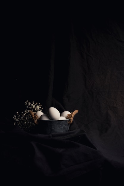 Free photo chicken eggs in bowl near plant