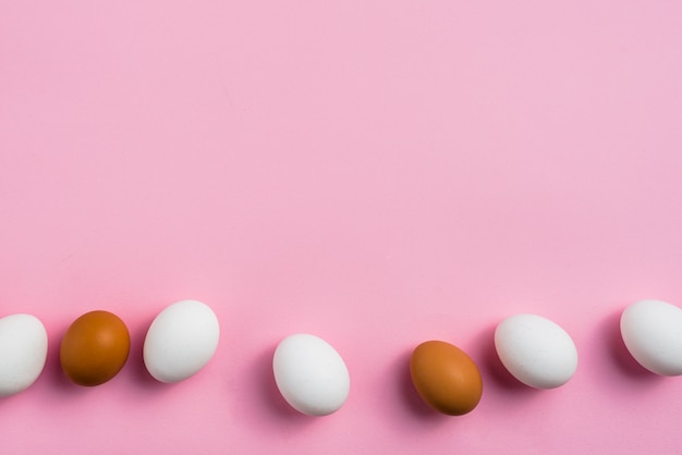 Free photo chicken eggs scattered on pink table