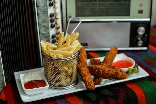 Free photo chicken fingers with french fries ketchup mayonnaise sweet chili sauce side viewjpg