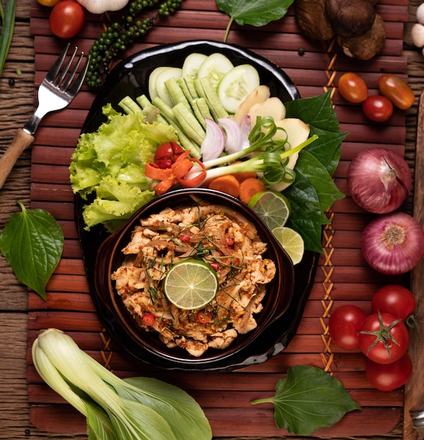 Free photo chicken larb on the plate with dried chilies, tomatoes, spring onions and lettuce