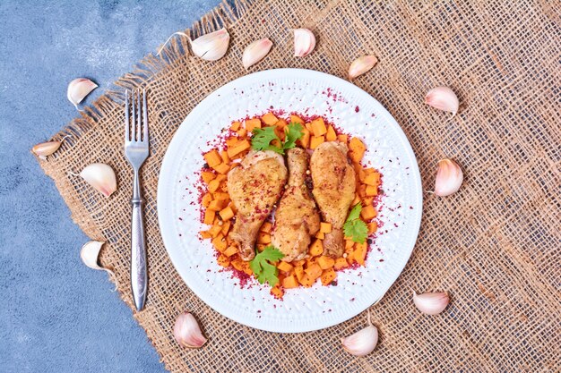 Chicken legs with sauces in a white plate.