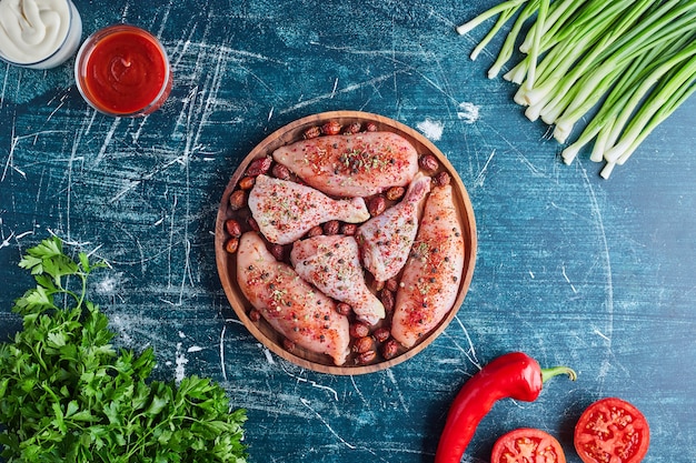 Chicken meat with red spices and vegetables around.