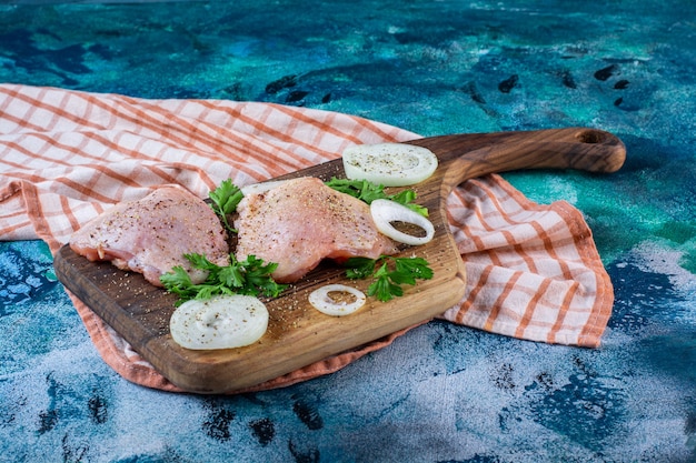 Free photo chicken meats on a cutting board on the tea towel