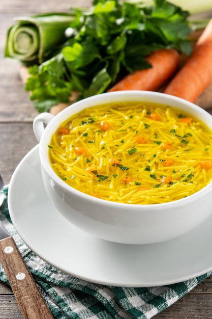 Free Photo chicken noodle soup in white bowl on wooden table