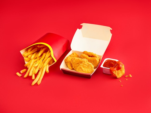 Free photo chicken nuggets and french fries on red