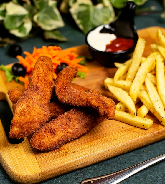 Chicken nuggets kfc style with french fries, mayonnaise, ketchup and vegetable salad   