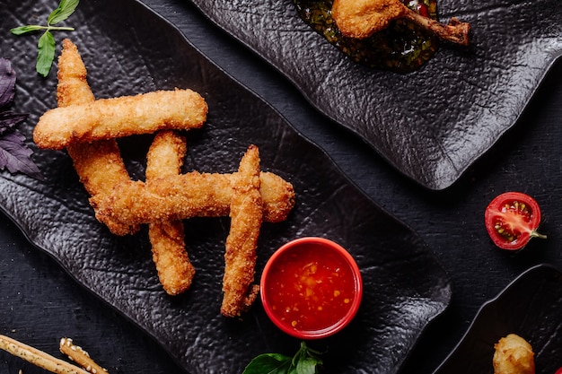 Free photo chicken nuggets with chili sauce in black plate.