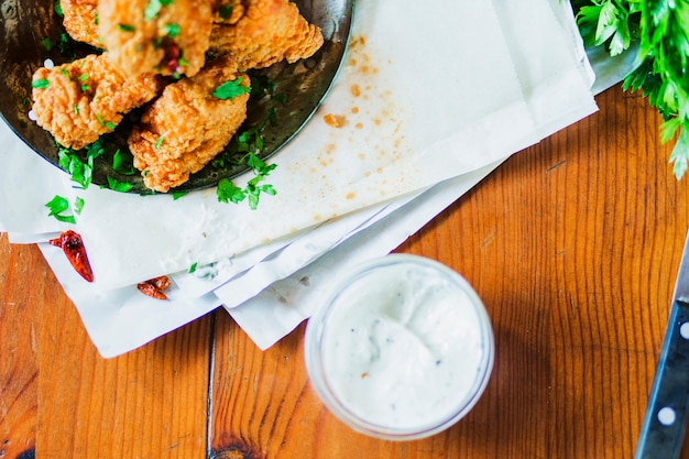 Chicken nuggets with delish garlic dip on wooden table