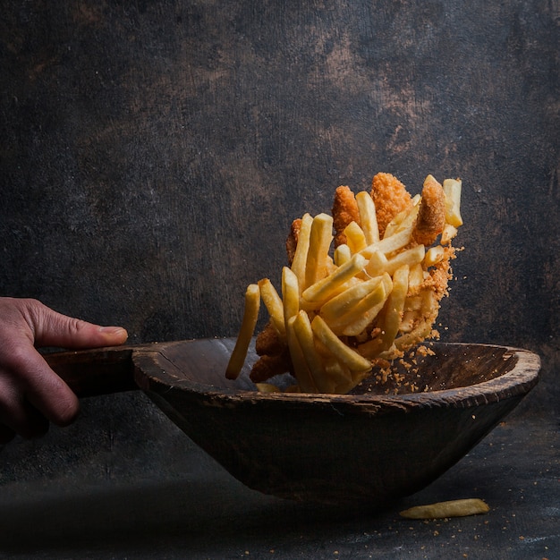 Free Photo chicken nuggets with french fries and human hand in fly