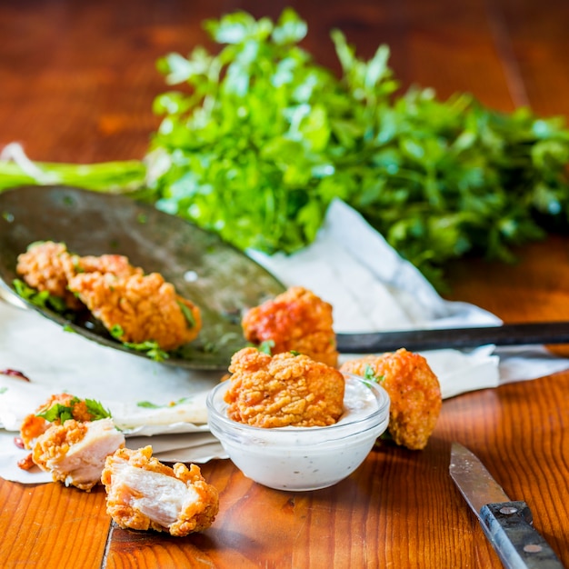 Free photo chicken nuggets with garlic dip on wooden table