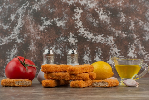 Free photo chicken nuggets with lemon, tomato, oil and garlic .