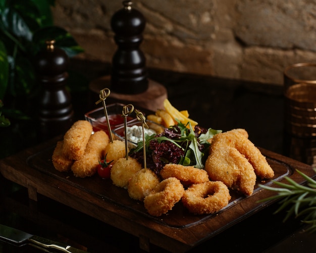 Free Photo chicken nuggets with onion sticks, fast food with green salad