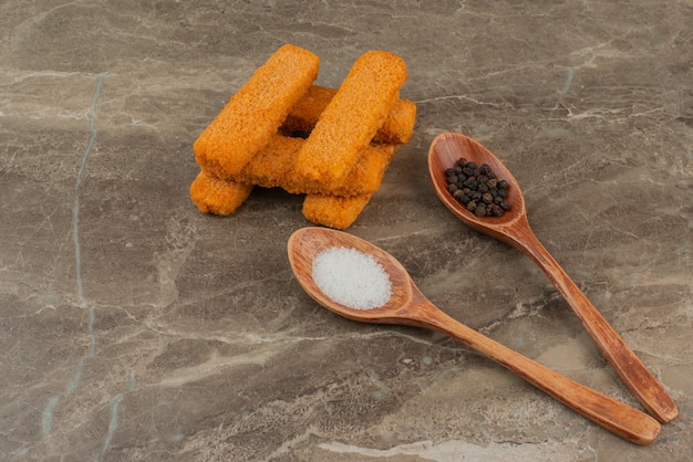 Chicken nuggets with spoon of salt and pepper.