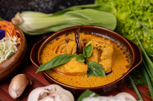 Free photo chicken red curry in a bowl with dried chilies, basil, cucumber and long beans