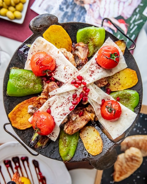 Chicken sadj potato bell pepper lavash pomegranate top view