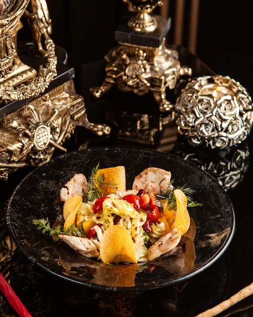 Free Photo chicken salad with vegetables and potato chips in a plate