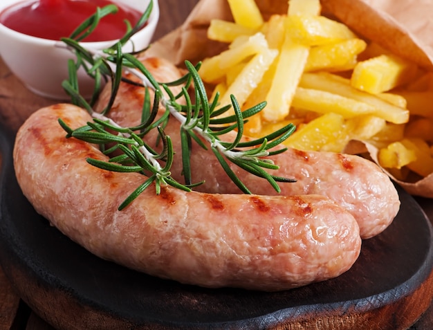 Free photo chicken sausages grilled with a side dish of  french fries