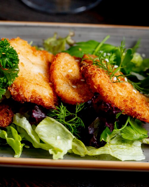 chicken schnitzel served with lettuce and greens