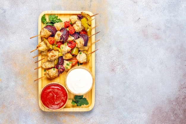 Chicken shish kebab with vegetables,ketchup,mayonnaise,top view