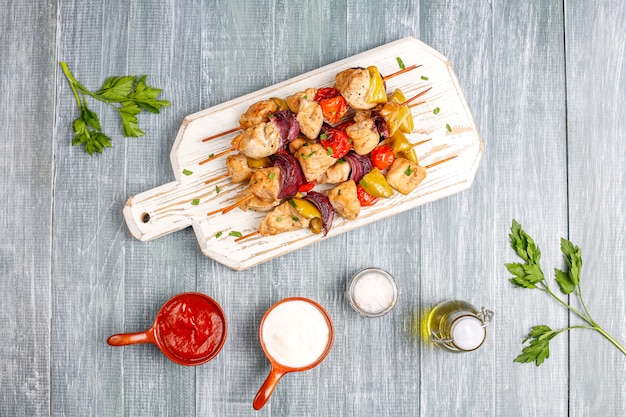 Free photo chicken shish kebab with vegetables,ketchup,mayonnaise