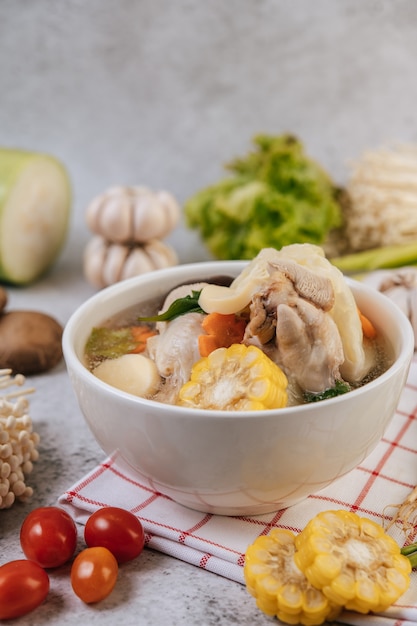 Chicken soup with corn, shiitake mushroom, enoki mushroom, and carrot.