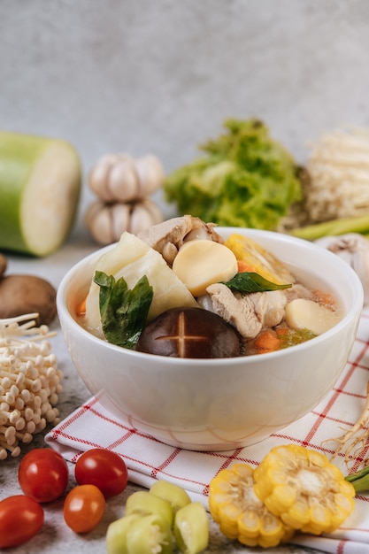 Chicken soup with corn, shiitake mushroom, enoki mushroom, and carrot.