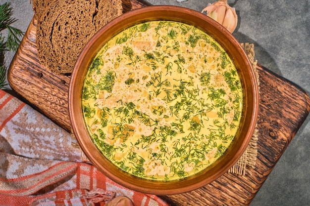 Free Photo chicken soup with vegetables and mushrooms, top view, close-up. served with black bread and garlic. a healthy hot winter lunch. layout on gray background