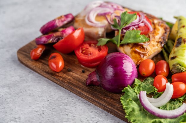 Chicken steak placed on a wooden tray.