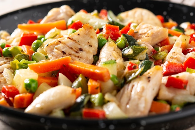 Free photo chicken stir fry and vegetables on wooden table