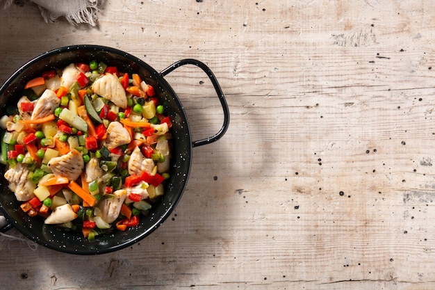 Free Photo chicken stir fry and vegetables on wooden table