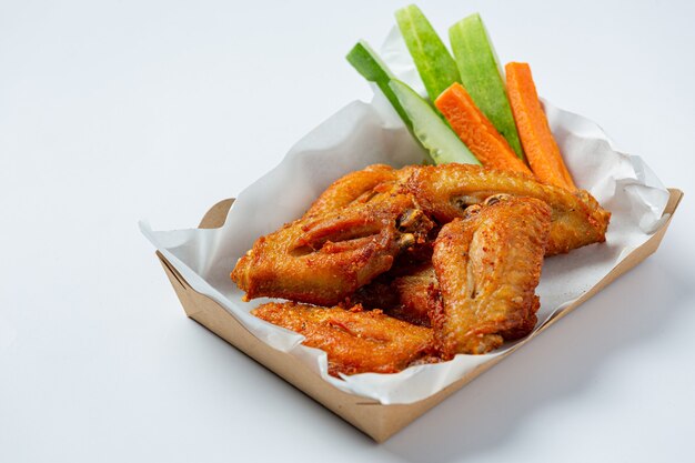 Chicken wings in paper box on a white