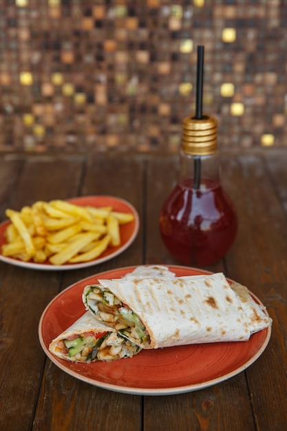 Chicken wrap with cucumber and tomato served with fries and kiwi cocktail