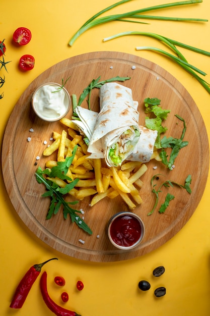 Free photo chicken wrap with side fries and herbs