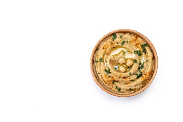 Chickpea hummus in a wooden bowl garnished with parsley paprika and olive oil