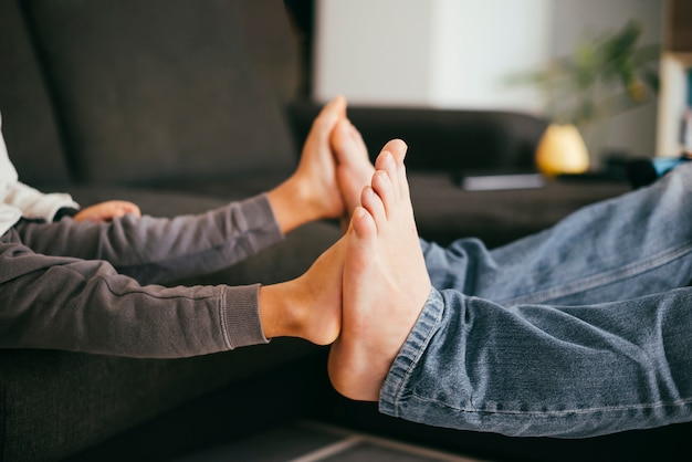 Child bare feet touching father feet