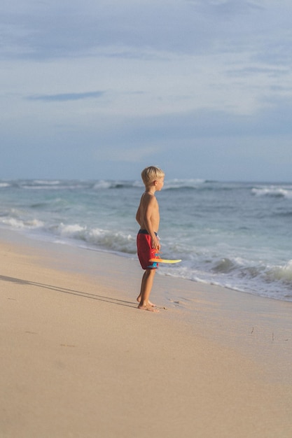 A child on the beach plays in the waves of the ocean. Boy on the ocean, happy childhood. tropical life.