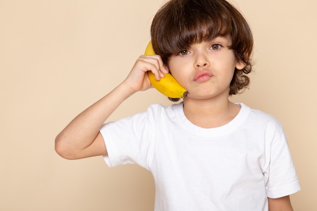 child boy cute adorable in white t-shirt with banana on pink