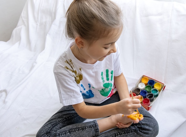 The child draws a pattern on his foot with a brush.