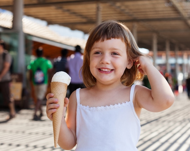 child  eating ice cream at street