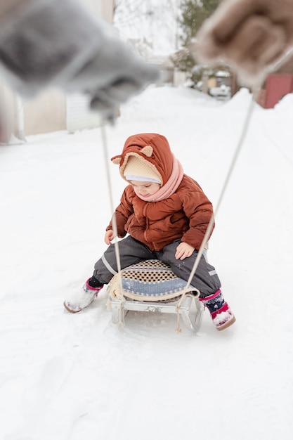 Child enjoying winter activities with their family