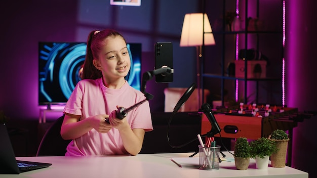 Free Photo child filming video with phone attached to selfie stick for online channel talking with viewers