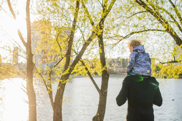 Free photo child on his father's shoulders enjoying nature