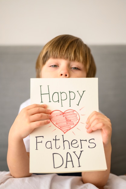 Free photo child holding father's day greeting card