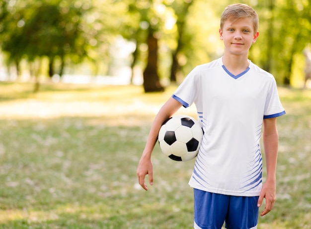 Child holding a football outdoors